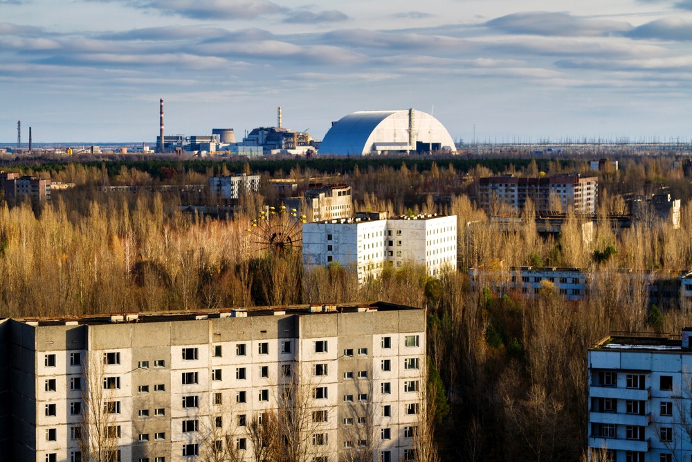 Blick aus der verlassenen Stadt Pripyat zum AKW Tschernobyl mit dem riesigen "Sarkopharg", der den zerst&ouml;rten Reaktor f&uuml;r 100 Jahre abschirmen soll. (Bild: kefirm)